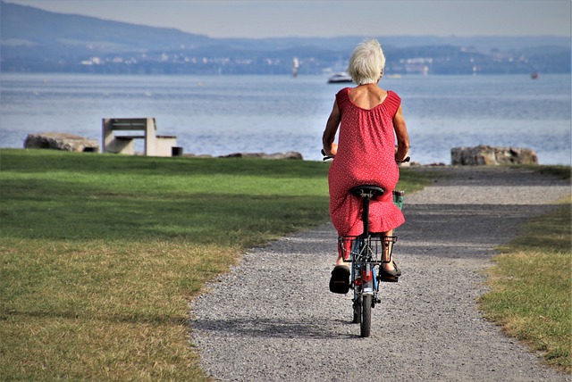 Older woman rides bicycle to the beach