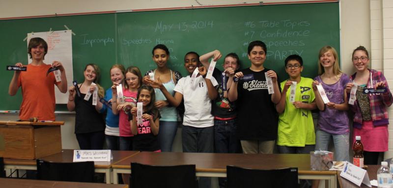 Youth holding up Toastmasters ribbons on celebrating