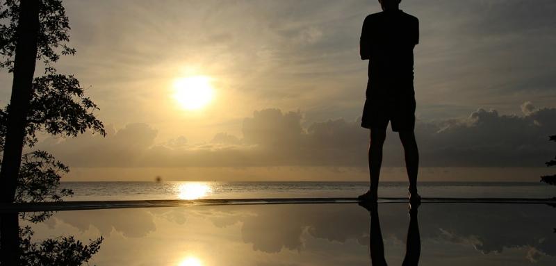 Silhouette of Man overlooking sea into Sunset